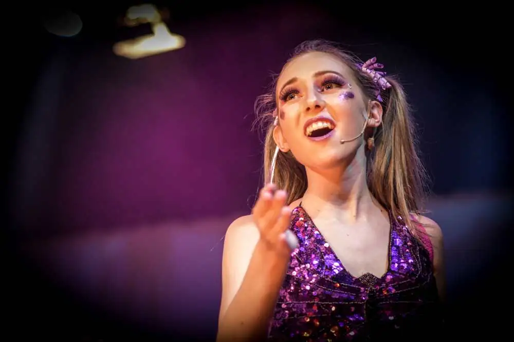A singer in a sparkly purple top