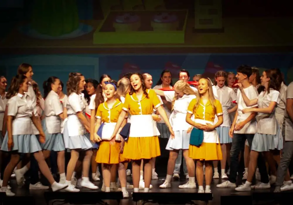 Waitresses in yellow singing in the diner