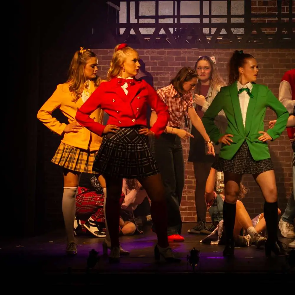 Three performers in bright blazers