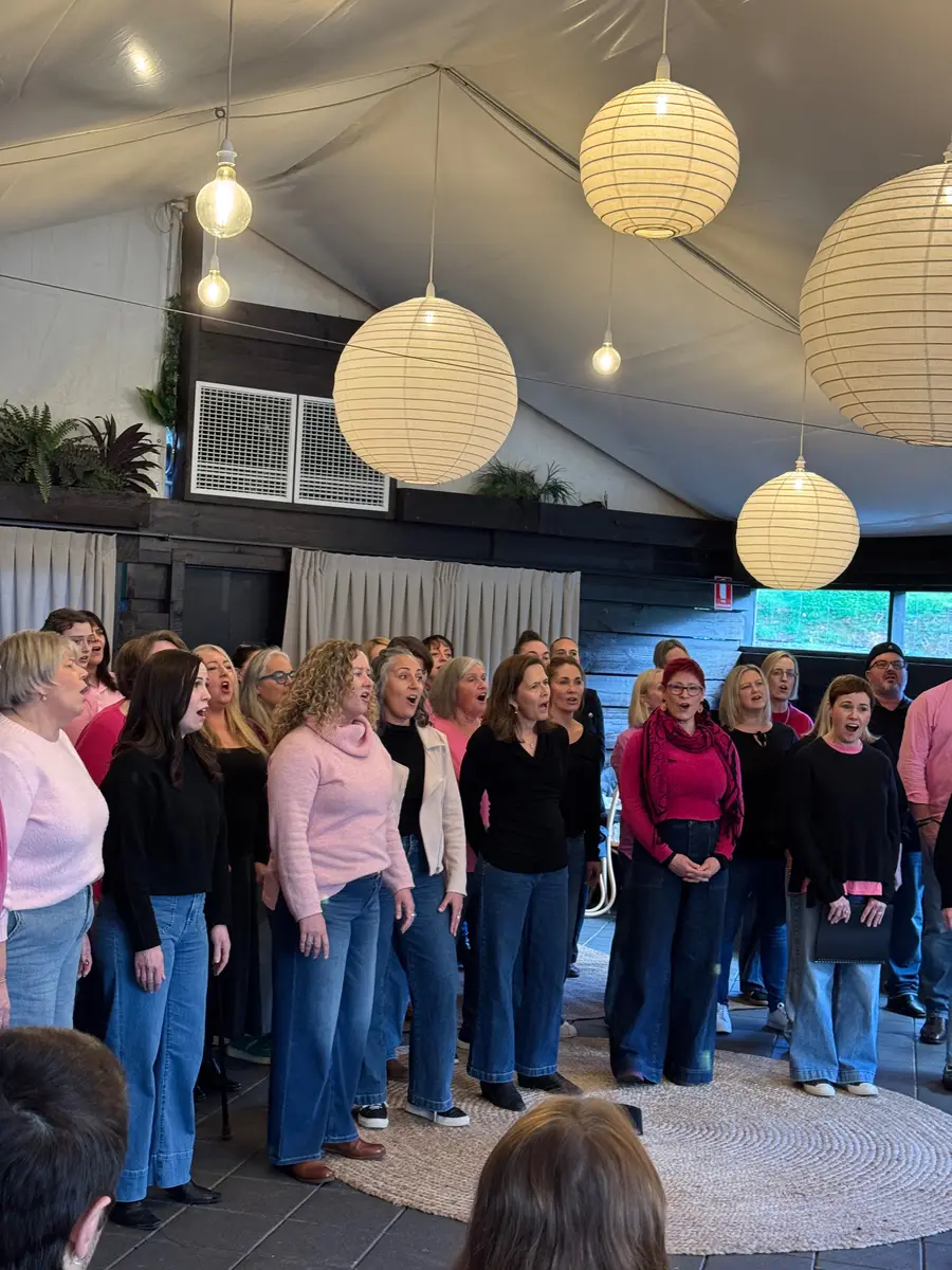 Sing!OZ members singing beneath paper lanterns at the winter solstice concert