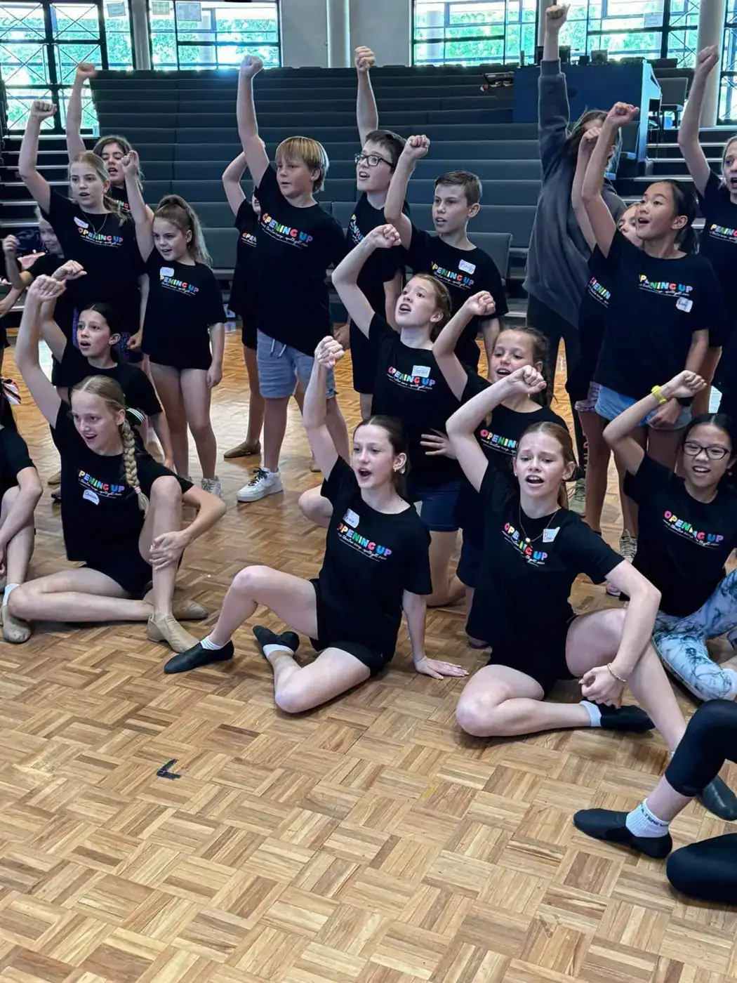Campers with fists raised during a rehearsal